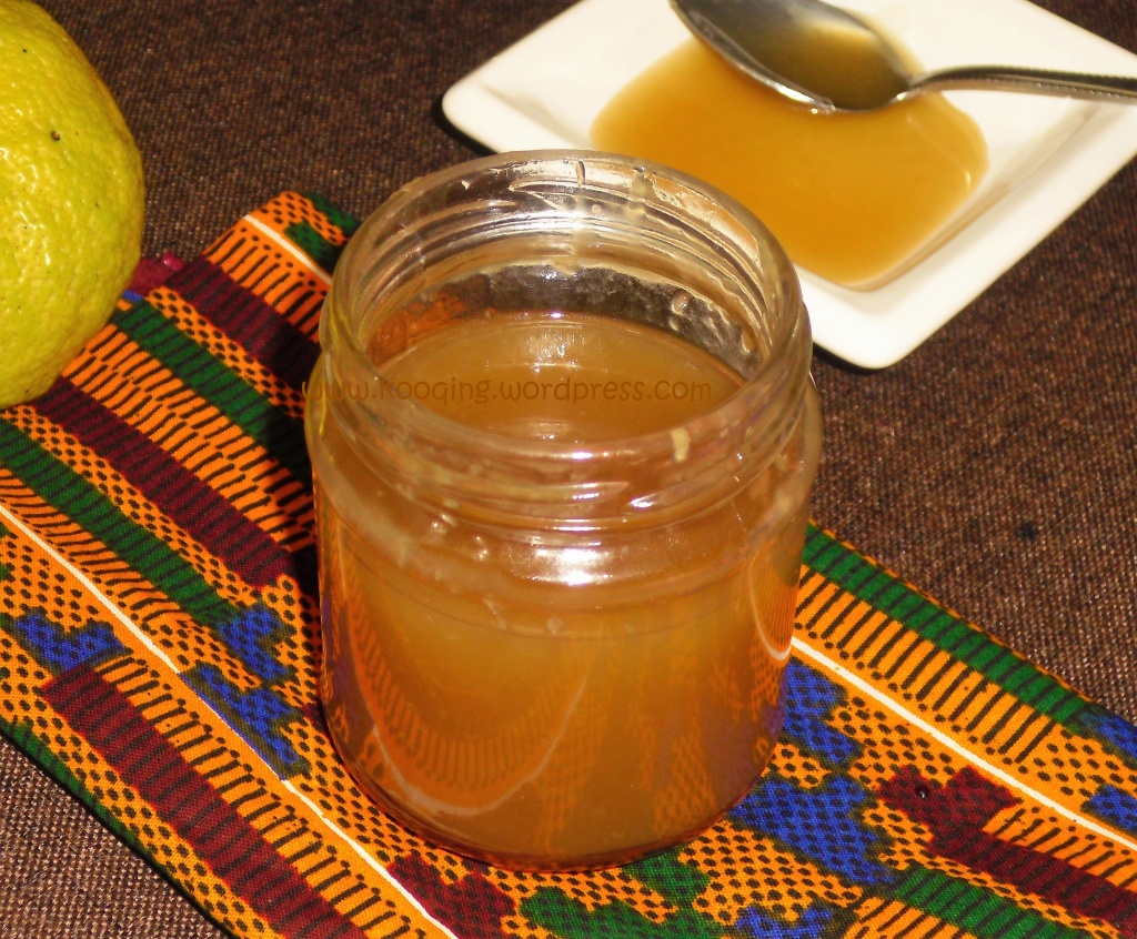 A jar of tangy coconut caramel sauce sitting on an african print cloth