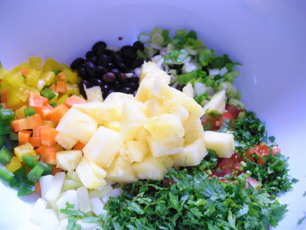 How to make black bean salad with pineapple; white mixing bowl with black beans, diced veggies and chopped pineapple 